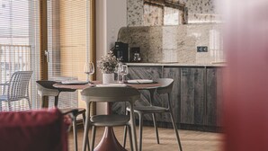 Un coin repas moderne avec une table ronde, deux chaises et un vase de fleurs.