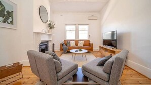A modern living room with a sofa set, a coffee table, a fireplace, and a television. - Kairos in Keswick—Character-filled Escape near CBD (Keswick)