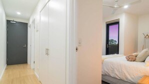 A bedroom with a bed, a ceiling fan, and a window with a view of the outside. - Canopy @ 44—Central CBD Location (Ovingham)
