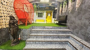 A staircase leading to a door with a neon sign reading "Asthar Home". - Astha Home Shared Pool Rooms (Mumbai)