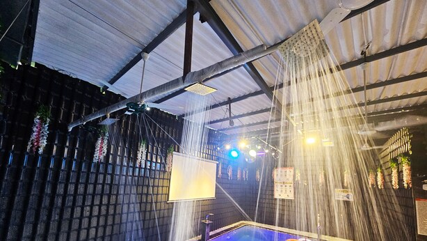 An indoor pool with water features, a ceiling fan, and a sign with safety instructions. - Astha Home Shared Pool Rooms (Mumbai)