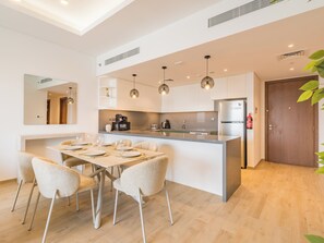 A modern kitchen with a central island, stainless steel appliances, and pendant lighting. - Central Park Residences -City Walk Dubai (Dubai)