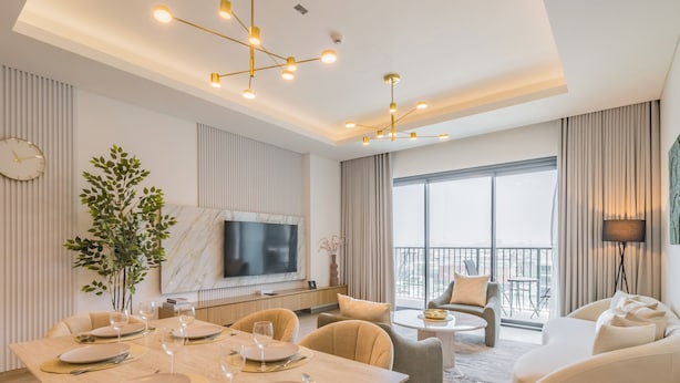 A modern hotel room with a dining area, a sofa, a TV, and a balcony with a view. - Central Park Residences -City Walk Dubai (Dubai)