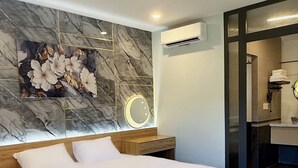 A modern bedroom with a wooden bed, marble wall, and a bathroom with a glass door. - Hoang Thien Homestay & Sport (2 Bao Loc)
