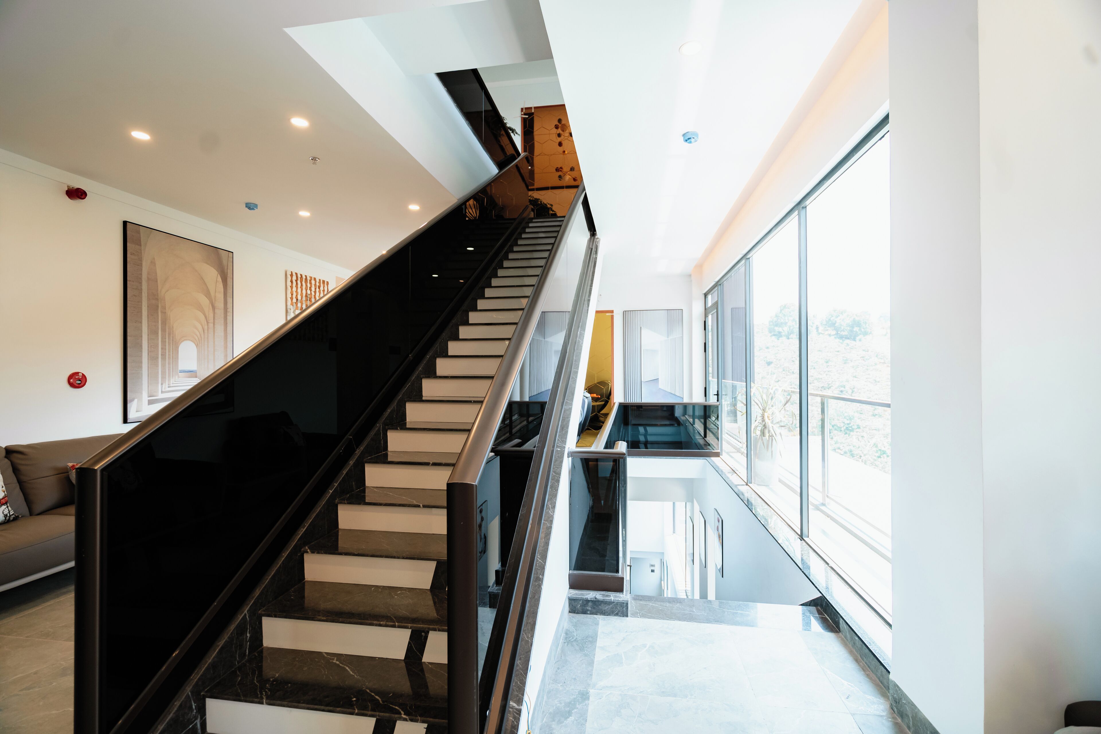 Un interior moderno con una escalera que lleva a un balcón.