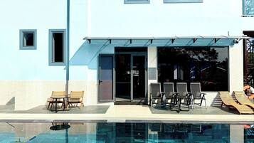 Ein modernes Gebäude mit Pool, Sitzgelegenheiten im Freien und einem überdachten Eingang.