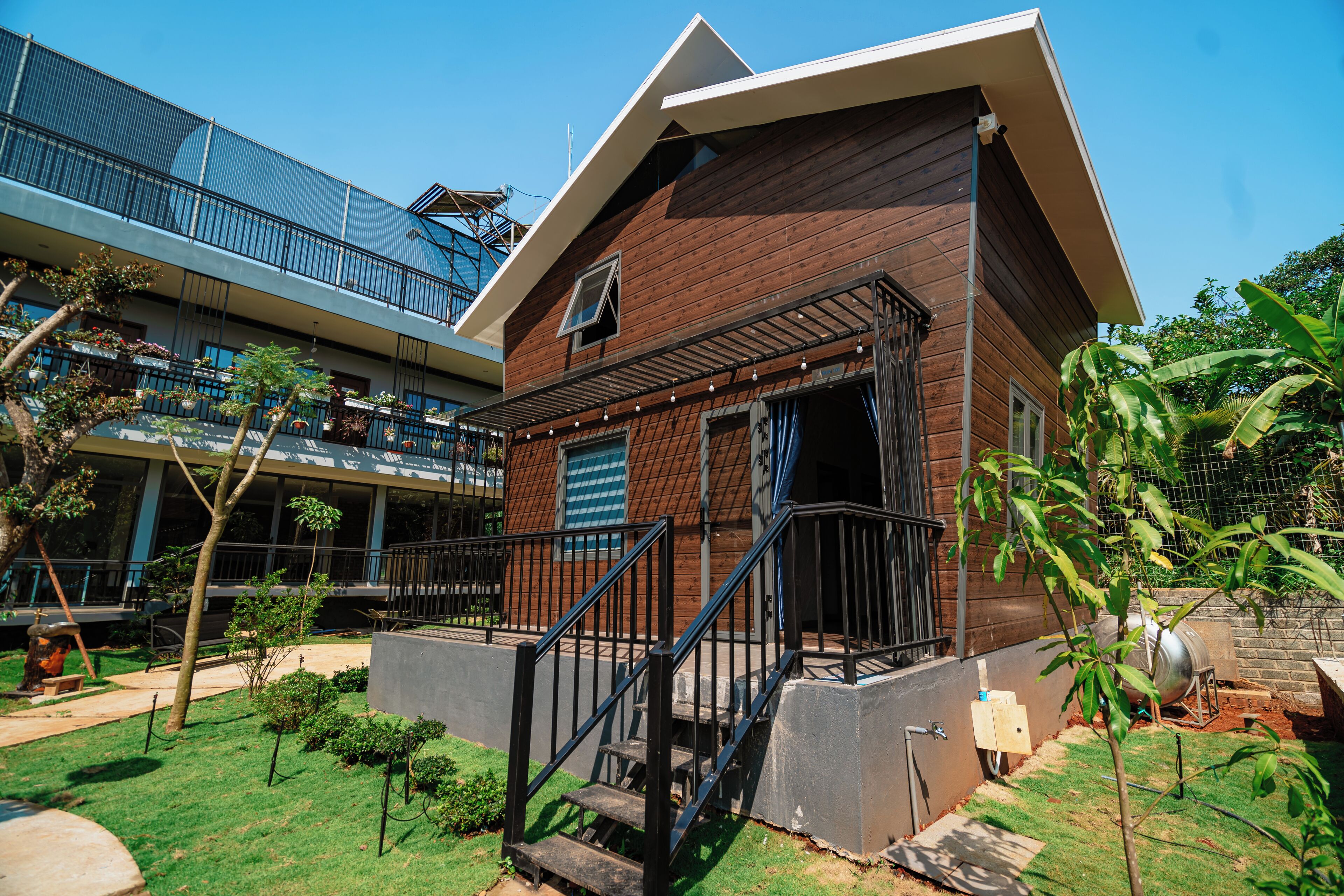 A modern building with a wooden facade, a balcony, and a staircase leading to the entrance.