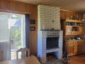 Un interior rústico con chimenea de piedra, armarios de madera y un comedor con mesa y sillas.