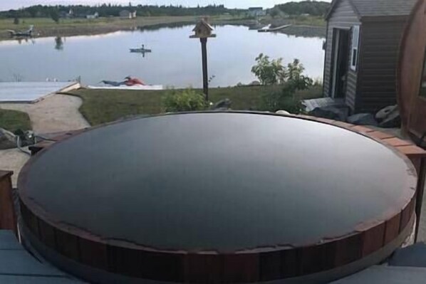 Terraza circular al aire libre con vistas a un lago y barcos.