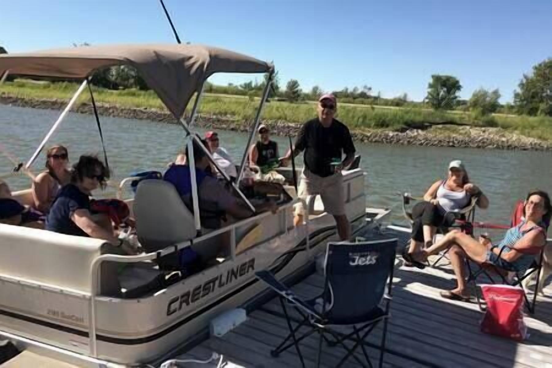 Un bote con toldo, personas a bordo y una silla amarrada.