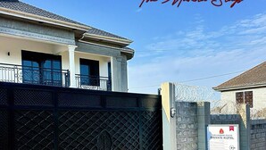 A private hotel with a gated entrance, a balcony, and a signboard. - The Marina Stays Private Hotel & Spa (Entebbe)