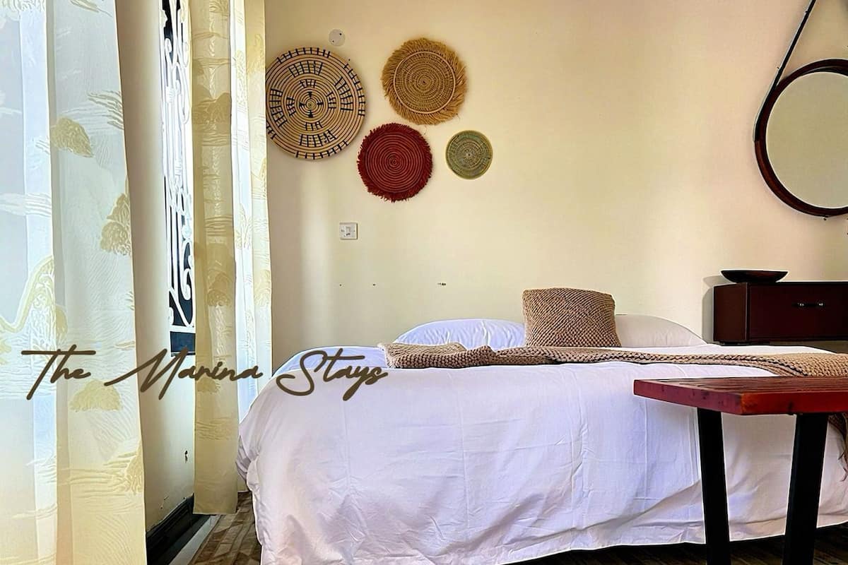 A bedroom with a bed, a wooden nightstand, and three wall-mounted circular wall hangings.