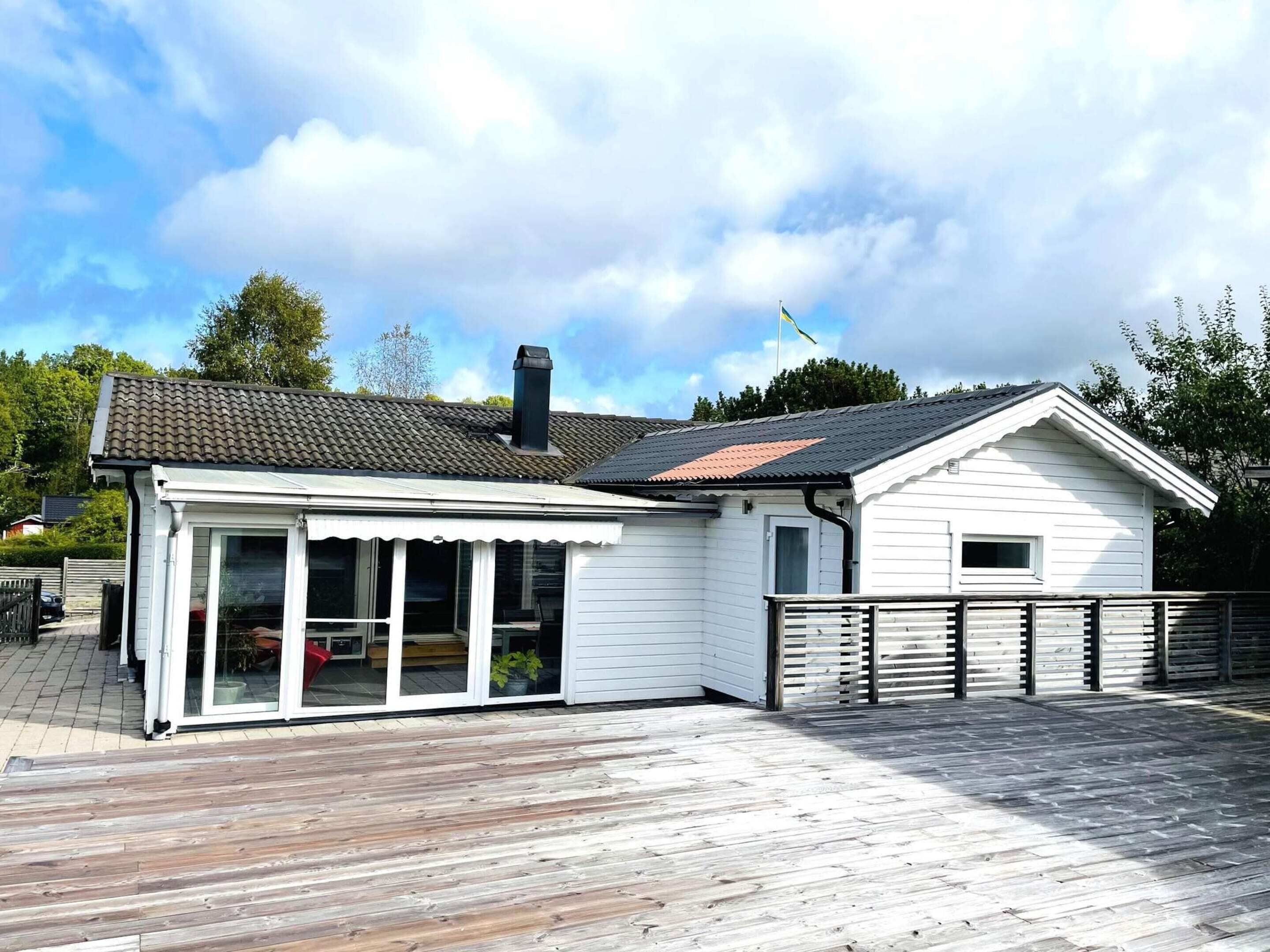 A two-story house with a wooden deck, a large sliding glass door, and a small attached garage.