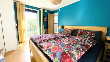 Un dormitorio con cama, cabecero de madera y vistas al exterior.