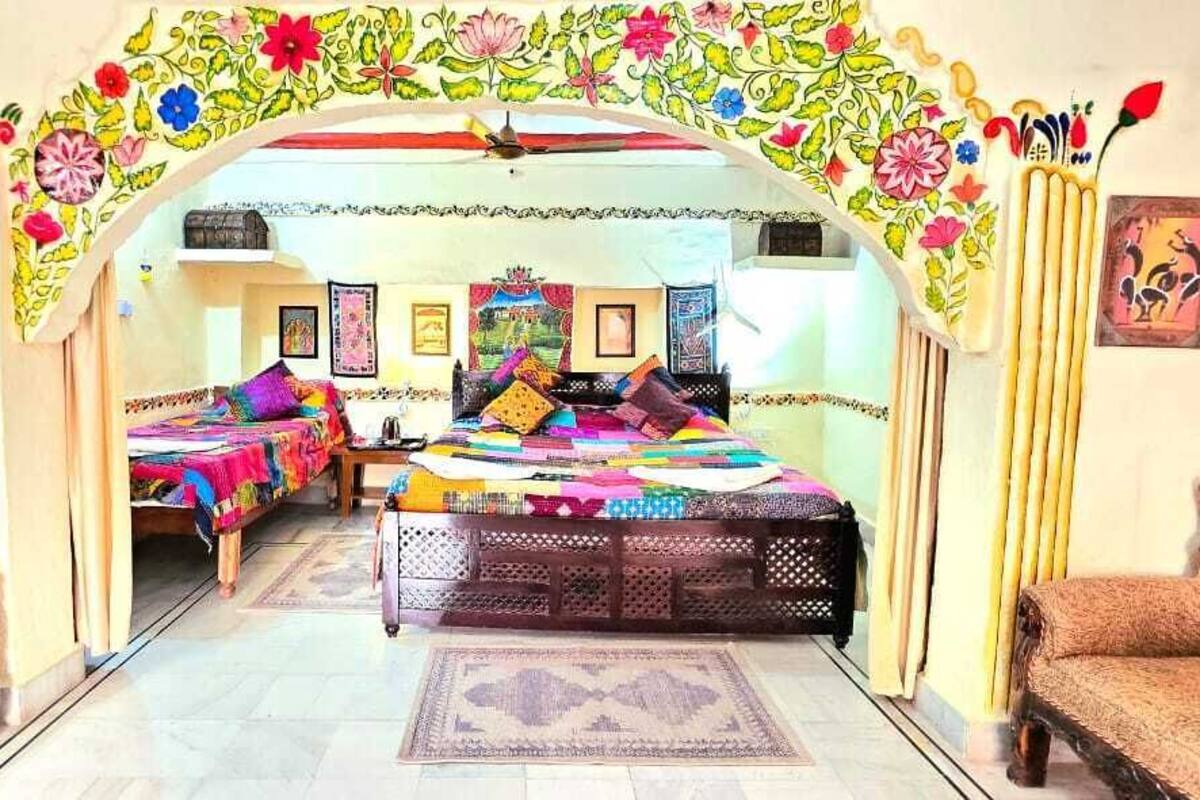 A traditional room with a bed, two sofas, and a patterned rug.