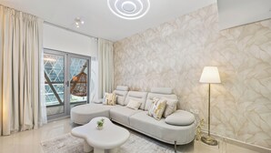 Un salon moderne avec un canapé d’angle, une table basse et un fauteuil suspendu.