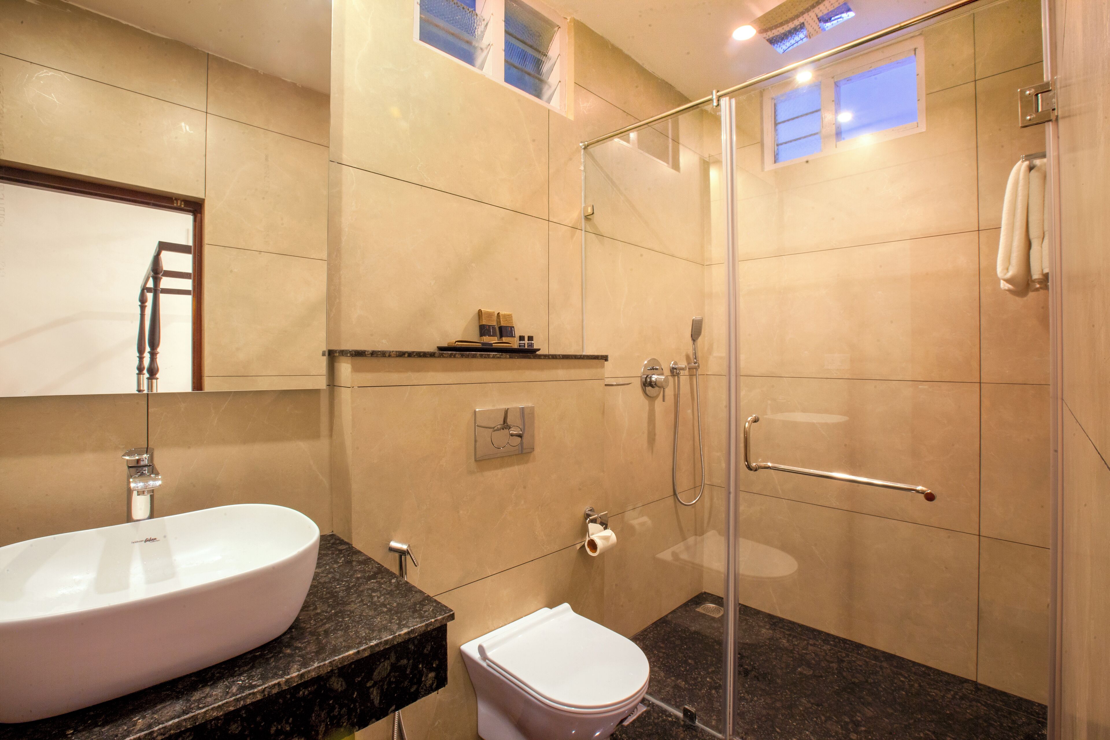 A modern bathroom with a white sink, toilet, and shower.