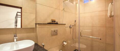 A modern bathroom with a white sink, toilet, and shower.