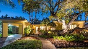 A well-lit residential property with a large tree in the front yard, a paved driveway, and a number '1793' on the building. - Mid-Century Oasis | Resort Backyard | Near Beach (Fort Lauderdale)