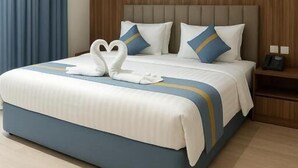 A hotel room with a large bed, a wooden headboard, and a painting on the wall. - Wafa Residence (Riyadh)