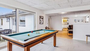 A pool table in a well-lit room with a view to the outside. - 4 Star Holiday Home in Pandrup (Pandrup)