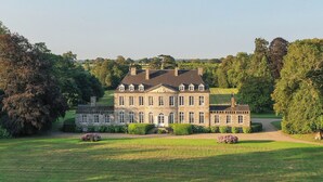 A large, historic building with a symmetrical facade, multiple windows, and a central entrance. - Holiday Home Château de Boucéel Mont Saint Michel (Saint-James)