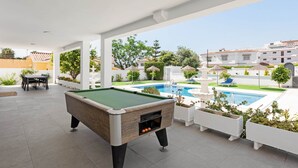 A pool table in an outdoor area with a view of a swimming pool and surrounding greenery. - Villa Selvetta - Luxury Villa next to Puerto Marina Benalmádena (Benalmádena)