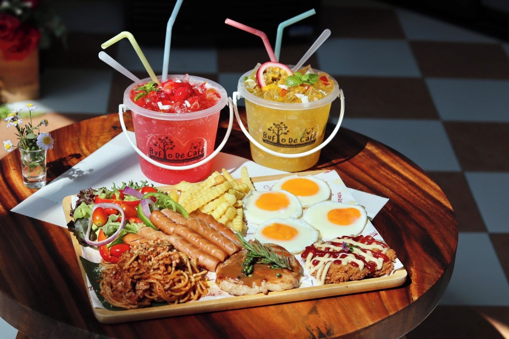 Bandeja de comida con ensalada, salchichas, pollo frito, huevos y un sándwich.
