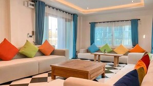A living room with two sofas, a coffee table, and a checkered floor. - Buffalo Island Resort & Adventure Park (Hang Dong)