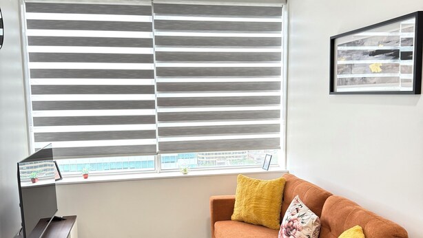 Un salon moderne avec un canapé, une table basse et un téléviseur posé sur un meuble.