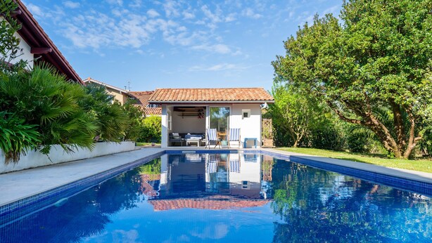 A swimming pool with a clear view of a house in the background. - Émilie's Guest Room - Anglet (Anglet)