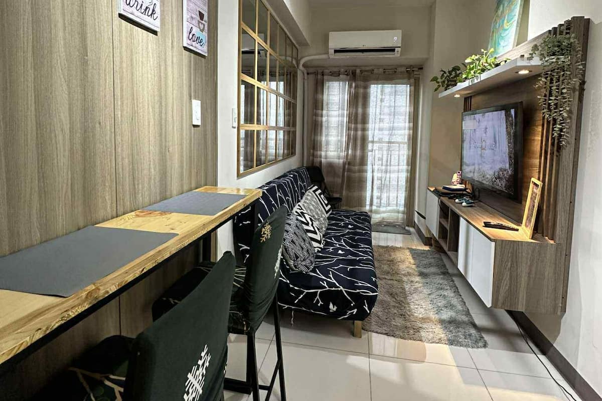 Un salon moderne avec un canapé, une table à manger et un téléviseur.