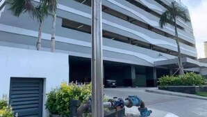 A modern high-rise building with multiple parking levels, a street sign for 'Dapitan' and 'Roxas Blvd', and a clear sky. - Modern Comfort in Pasay with Pool (Pasay)
