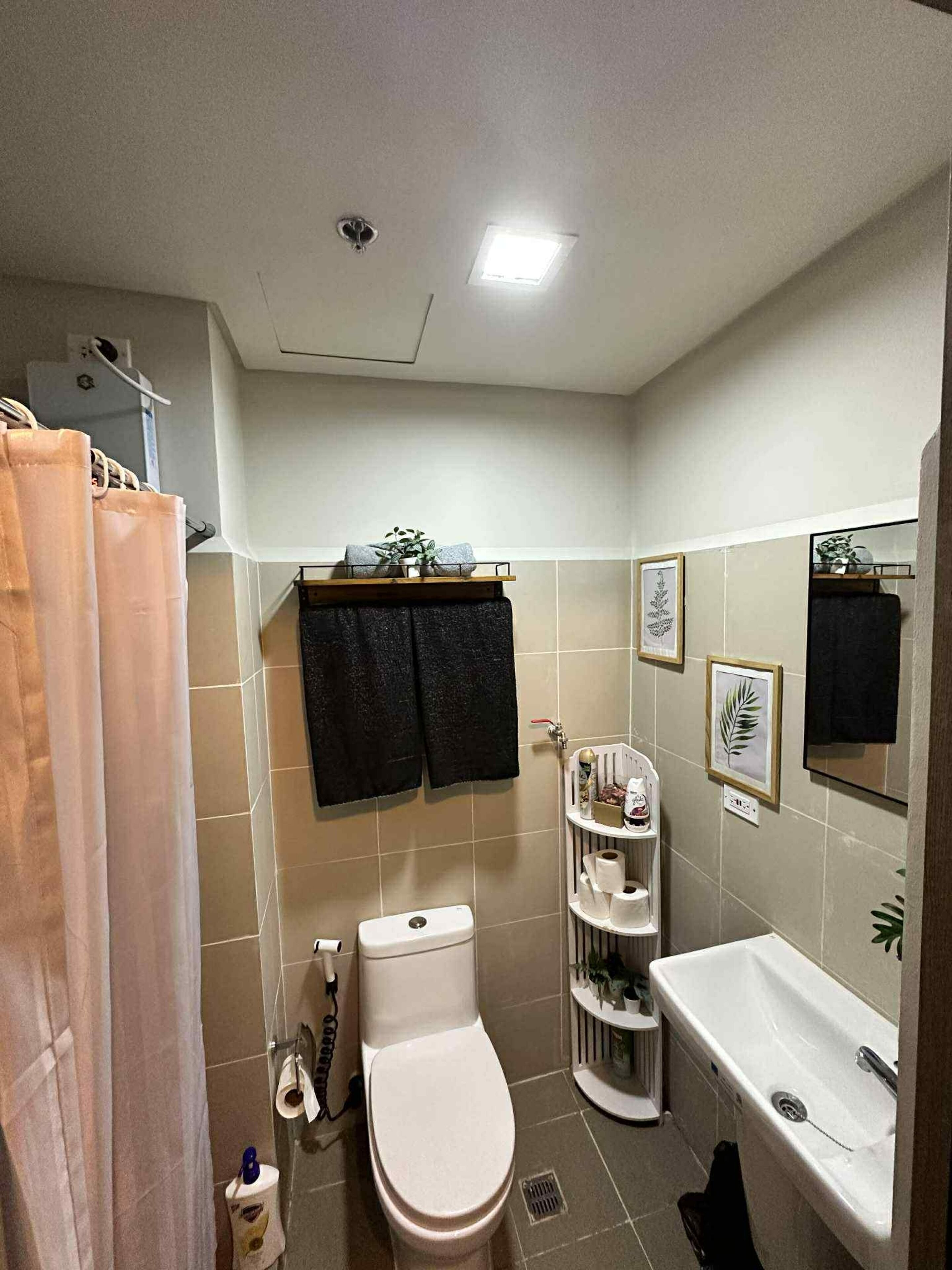 A bathroom with a toilet, sink, and shower curtain.