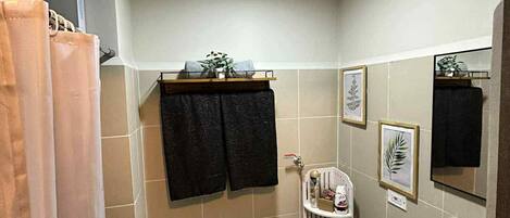 A bathroom with a toilet, sink, and shower curtain.
