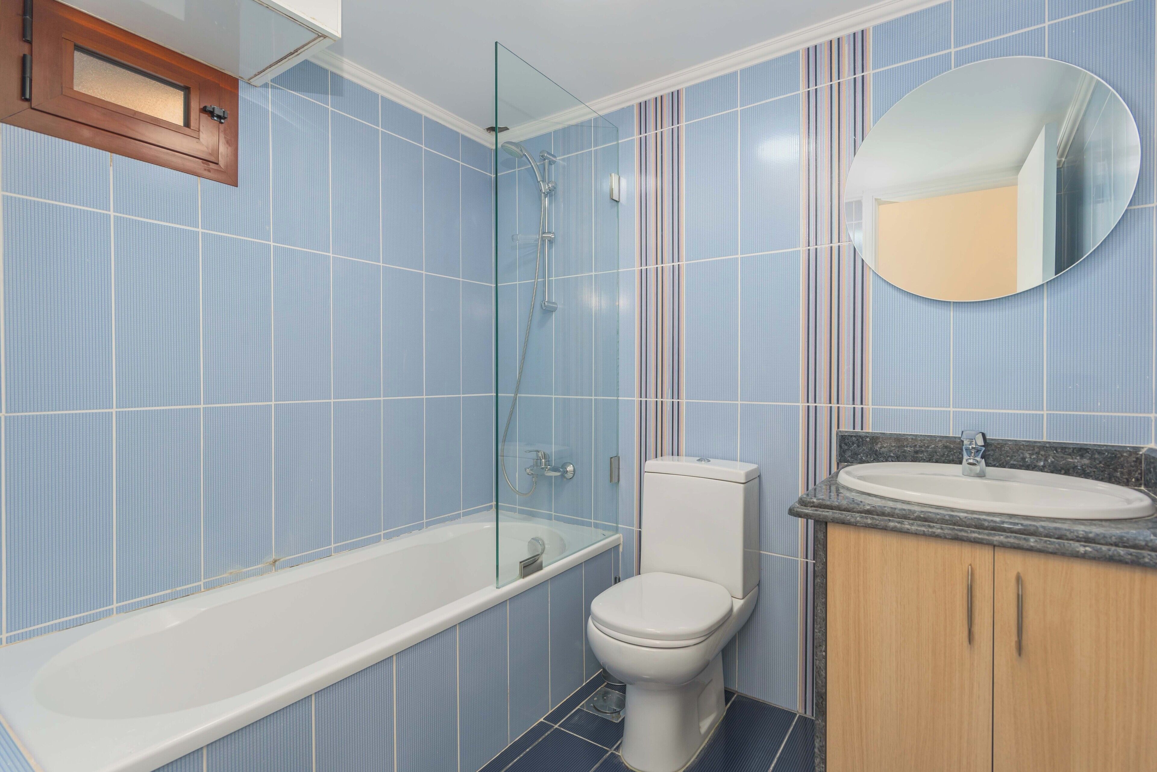 A bathroom with a bathtub, toilet, and a sink with a mirror.