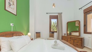 A bedroom with a large bed, a dresser, a mirror, and a window with curtains. - Beit Salima 3BR House with Pool (Salima)