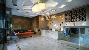 A spacious lobby with a marble floor, a reception desk, a sofa, and a chandelier. - Atakum Palas Otel (Atakum)
