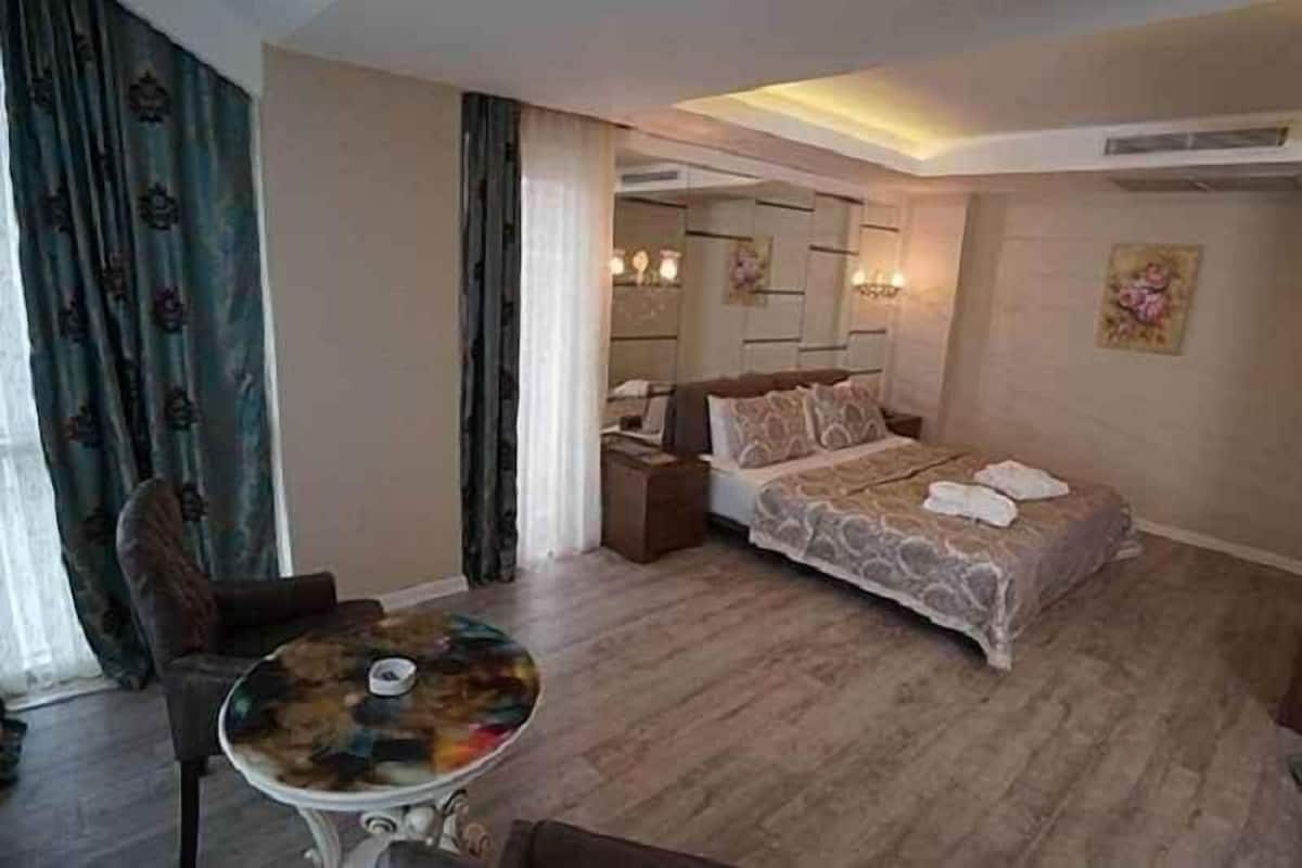 Een hotelkamer met een bed, een ronde tafel, een stoel en een nachtkastje.