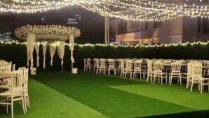 An outdoor event space with tiered seating, string lights, and a stage with draped fabric. - Atakum Palas Otel (Atakum)