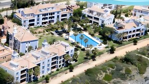 Zona residencial con varias edificaciones de dos pisos, una piscina y una playa.