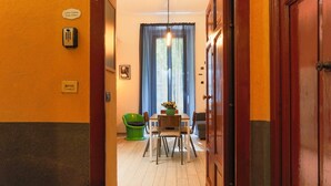 Un couloir d’hôtel avec un coin repas, un téléphone et un panneau indiquant « CASA Cestino, suites à deux lits ».