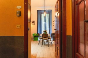 A hotel corridor with a dining area, a telephone, and a sign indicating 'CASA Cestino Twin Suites.'