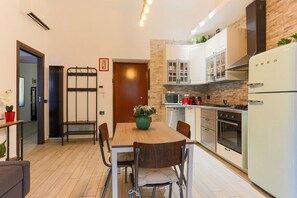 A modern kitchen with white cabinets, a microwave, stove, and a white refrigerator.
