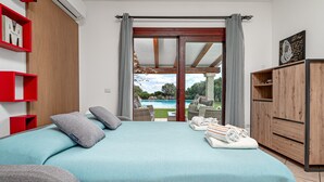A bedroom with a bed, a view of a pool, and a wooden wardrobe. - Apartment 'Sarda Bella Private Pool' with Mountain View, Wi-Fi and Air Conditioning (Rudalza)