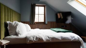 Quarto com cama, telefone, janela e televisão.