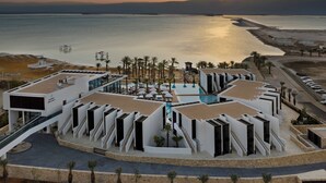 A modern hotel with a pool, palm trees, and a sunset view. - Kayma By Isrotel Exclusive (Tamar)
