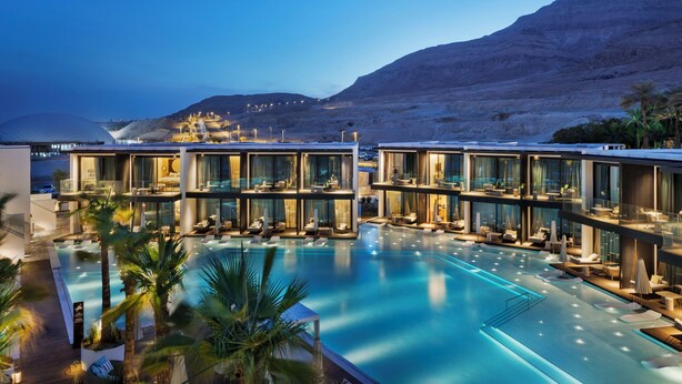 A modern hotel with a large pool, outdoor seating, and a view of the mountains. - Kayma By Isrotel Exclusive (Tamar)