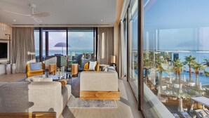 A modern hotel room with a large balcony, a sofa set, a coffee table, and a view of the ocean. - Kayma By Isrotel Exclusive (Tamar)