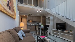 Een modern appartement met een woonkamer, keuken en eetgedeelte.